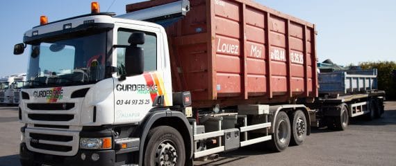 Camion Gurdebeke Recyclage équipé d'un bras ampliroll portant une benne